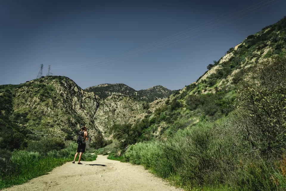 Lone hiker on gravel trail at Eaton Canyon Natural Area, Los Angeles County